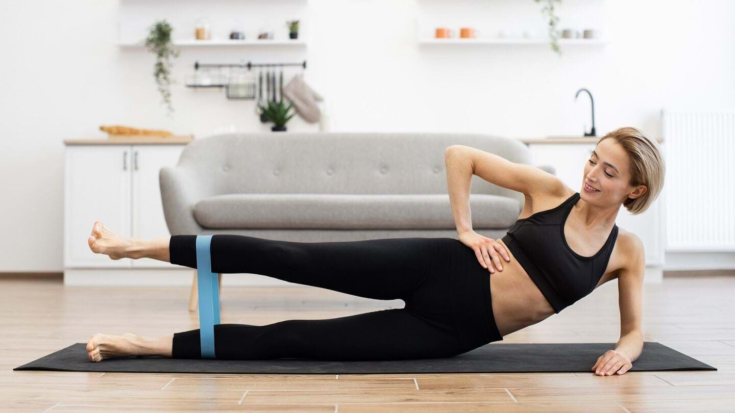 Woman doing side lying hip abduction with resistance band