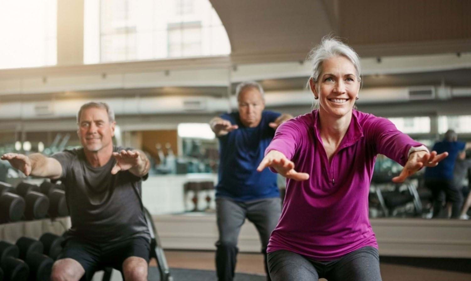 3 people squatting with their arms out