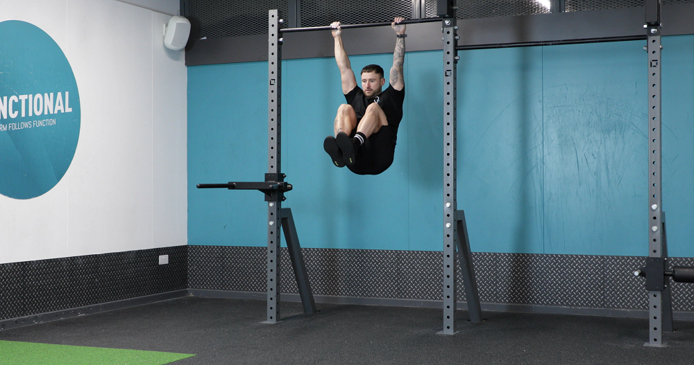 PT demonstrating how to do hanging knee raises exercise