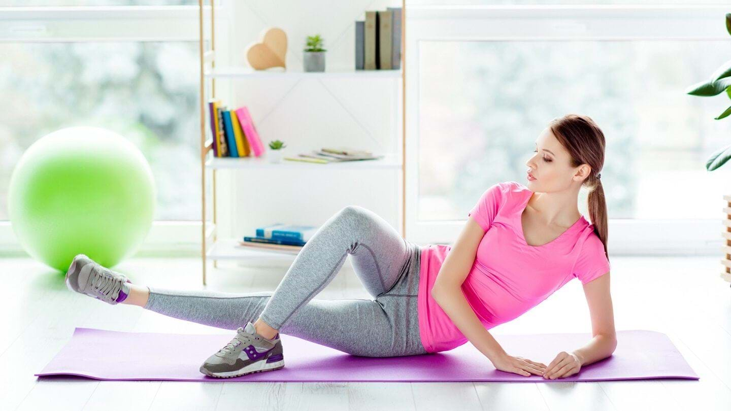 Woman doing side lying hip adduction exercise